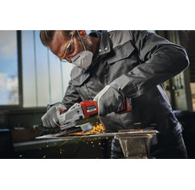 Artisan portant des vêtements de protection utilisant une meuleuse d'angle sans fil Einhell pour travailler une pièce métallique avec étincelles.
