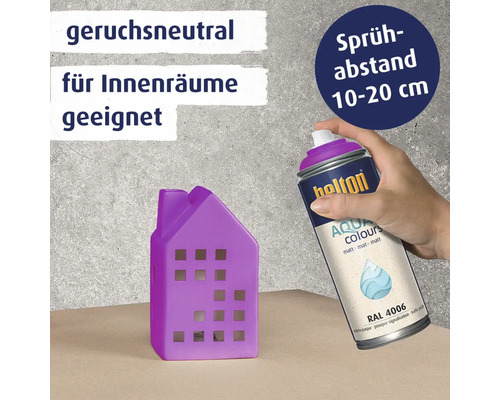 Eine Hand hält eine Belton Aqua Spraydose um ein kleines Deko Haus zu besprühen. Informationen zu Geruchsneutralität und Sprühabstand sind vorhanden.