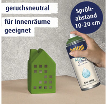 Eine Hand sprüht mit einer Belton Aqua Colours Sprühdose auf ein grünes Deko Haus aus Keramik.