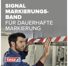 Ein Mann klebt ein gestreiftes Tesa Signal Markierungsband an eine Kante. Tesa Logo.