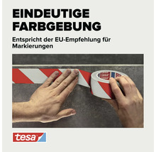 Tesa Markierungsband mit Warnstreifen bei der Anwendung auf einer Oberfläche, Tesa Logo.