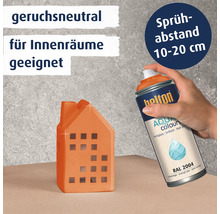 Eine Hand sprüht mit einer Belton Aqua Colours Sprühdose auf ein kleines Dekohaus. Die Farbe ist geruchsneutral und für Innenräume geeignet.
