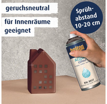 Hand beim Besprühen eines kleinen Hausmodells mit Belton Aqua Sprühlack RAL 8017 für Innenräume.