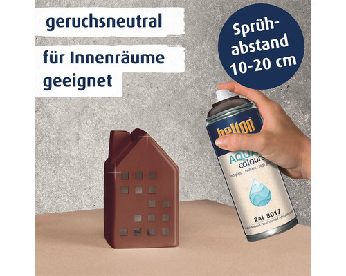 Hand beim Besprühen eines kleinen Hausmodells mit Belton Aqua Sprühlack RAL 8017 für Innenräume.