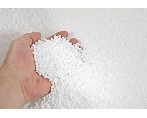 Eine Hand voll kleiner weißer Polystyrolkügelchen als Dämmmaterial oder Füllstoff.