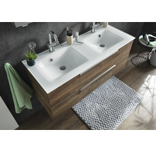 Double vasque avec lavabo en céramique blanche et meuble sous vasque imitation bois avec deux tiroirs dans une salle de bains moderne.