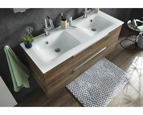 Double vasque avec lavabo en céramique blanche et meuble sous vasque imitation bois avec deux tiroirs dans une salle de bains moderne.