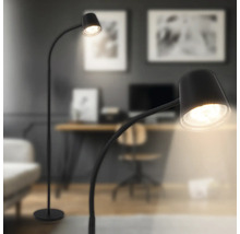 Lampadaire moderne avec bras incurvé et abat jour rond dans un salon au design élégant