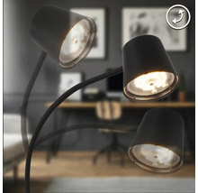 Lampadaire à trois bras articulés et spots réglables dans un bureau au design moderne.