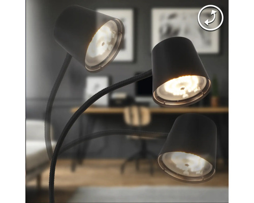 Lampadaire à trois bras articulés et spots réglables dans un bureau au design moderne.