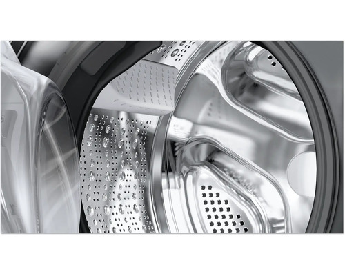 Vue détaillée du tambour en acier inoxydable d'une machine à laver avec aubes et perforation.