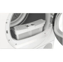 Sèche-linge ouvert avec filtre à peluches amovible dans la partie inférieure de l'ouverture de la porte.