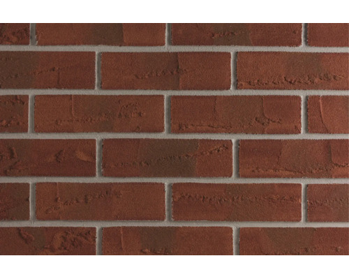 Gros plan sur un mur en briques avec des briques texturées et des joints gris
