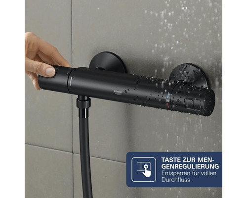 Grohe Thermostat Duscharmatur mit Mengenregulierung und Handbedienung an einer Wandfliese mit Wassertropfen.