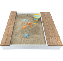 Rechteckiger Sandkasten aus Holz mit zwei seitlichen Sitzbänken und verschiedenem Spielzeug im Sand