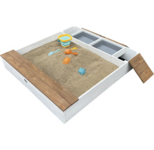 Sandkasten aus Holz mit integrierten Spielfächern und Sandspielzeug gefüllt mit Sand.