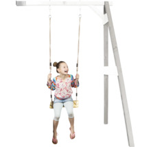 Un enfant joyeux se balance sur une balançoire en bois fixée à une aire de jeux en bois.