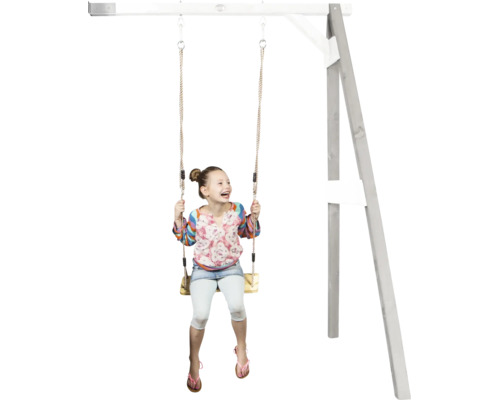 Un enfant joyeux se balance sur une balançoire en bois fixée à une aire de jeux en bois.