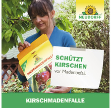 Eine Frau hält eine Neudorff Kirschmadenfalle in den Händen, um Kirschen im Garten vor Madenbefall zu schützen.