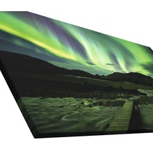 Leinwandbild mit Nordlichtern über einer Berglandschaft und einem Holzsteg