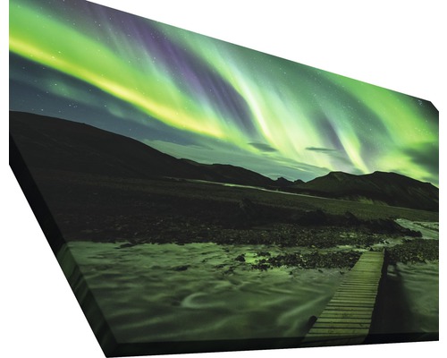 Leinwandbild mit dem Motiv Nordlichter über einer Landschaft mit einem Fluss und einer Holzbrücke.
