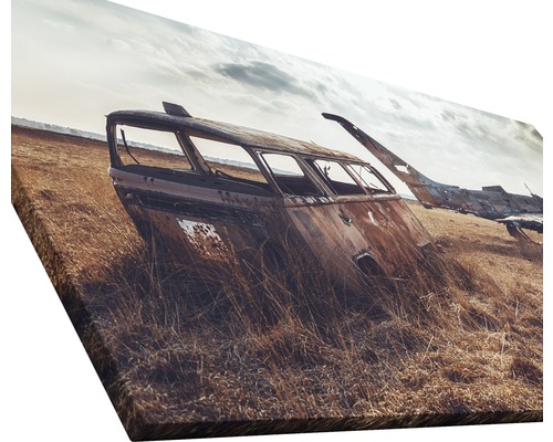 Image sur toile représentant une scène de carcasse de voiture rouillée dans un champ