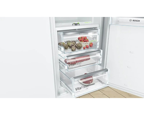 Réfrigérateur ouvert avec tiroirs VitaFresh pour conserver les aliments et les légumes. Logo Bosch.