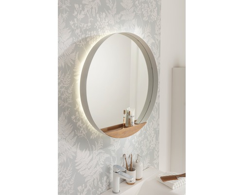 Runder Badezimmerspiegel mit Beleuchtung und Ablage im Badezimmer.