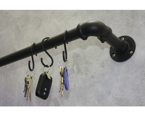 Schlüsselbrett aus Eisenrohr mit S-Haken und Schlüsseln an grauer Wand