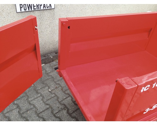 Vue détaillée d''une remorque rouge avec plateau de chargement ouvert.