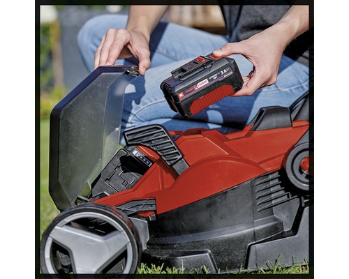 Ein Akku wird in einen Rasenmäher eingesetzt.