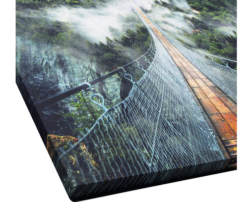 Nahaufnahme eines Kunstdrucks mit einer Hängebrücke über einen bewaldeten Canyon