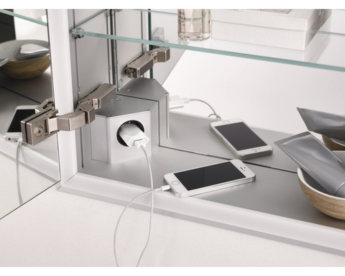 Detailaufnahme eines Spiegelschranks mit integrierter Ladestation für Mobiltelefone