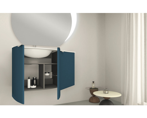 Salle de bains moderne avec miroir rond, lavabo et meuble sous-vasque avec portes ouvertes.