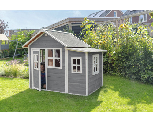 Maison de jeu en bois grise avec fenêtres et porte dans le jardin