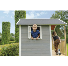 Spielhaus mit Kind am Fenster und Mädchen auf der Veranda im Garten
