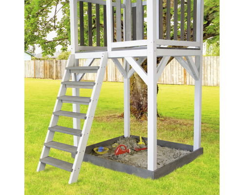 Spielturm mit Leiter und Sandkasten im Garten.