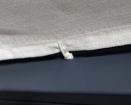 Detailaufnahme einer Gardine mit Faltenlegehaken zur Befestigung.