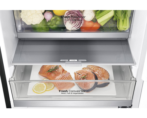 Intérieur du réfrigérateur avec des légumes et du poisson dans les compartiments fraîcheur