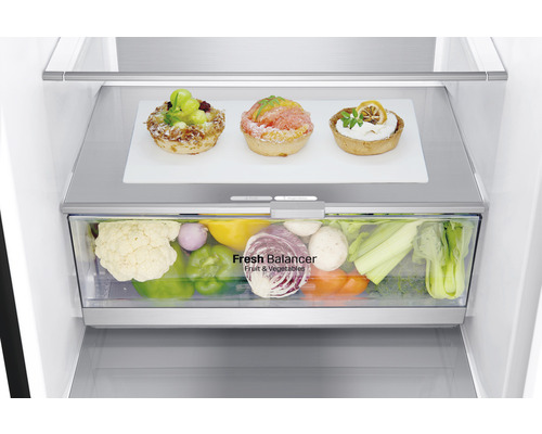 Kühlschrank Innenraumansicht mit Obst- und Gemüseschublade und Törtchen