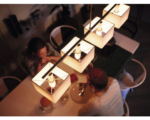 Lampe suspendue avec abat-jour en tissu au-dessus d'une table à manger dans une salle à manger.