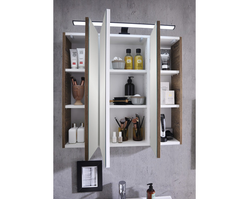 Armoire de toilette ouverte dans une salle de bains avec divers articles de bain et éclairage