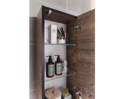 Armoire de salle de bain ouverte avec produits de soins sur étagères en verre