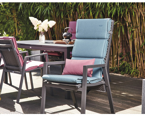 Scène de mobilier de jardin avec chaises, table et coussins sur une terrasse
