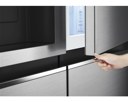 Gros plan d''un réfrigérateur avec une personne ouvrant une porte pour montrer l''intérieur.