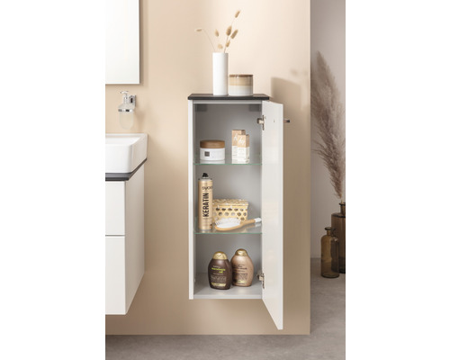 Salle de bains avec armoire suspendue, lavabo et divers accessoires de salle de bains.