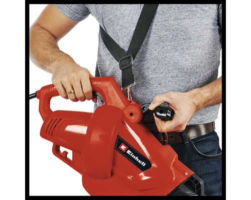 Eine Person bedient einen Laubsauger mit Tragegurt.