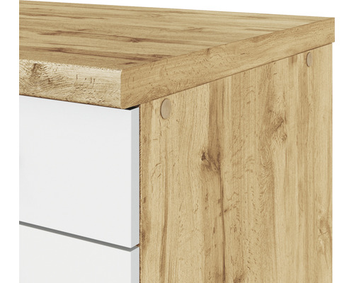 Detailaufnahme eines Schranks mit weißen Schubladen und Holzdekor