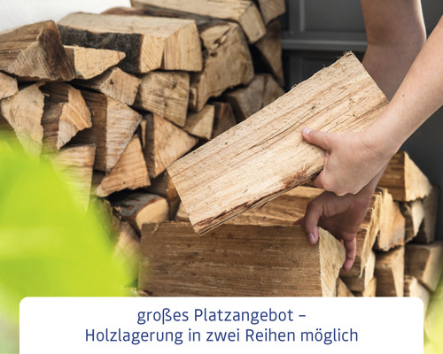Person stapelt Brennholz für die Holzlagerung