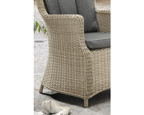 Detailansicht eines Korbsessels mit grauen Polstern.